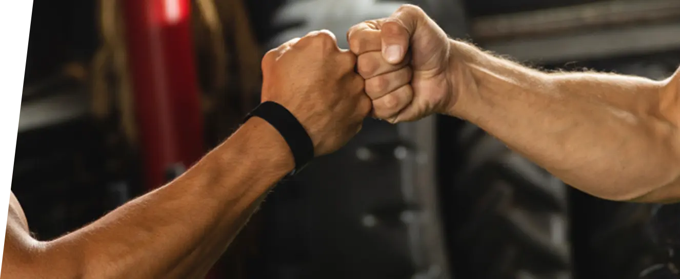 信頼関係を示す握手のように拳を合わせるトレーナーとクライアントの写真